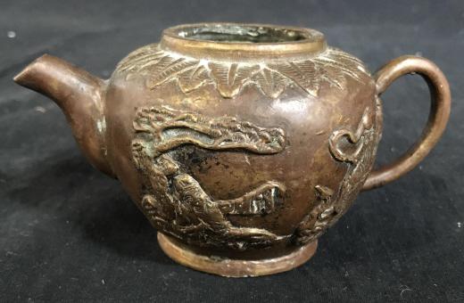 Antique Bronze Chinese Tea Pot: Antique Bronze Chinese Tea Kettle. The piece is decorated with a relief. Th piece measures approx 2.5 inches H and 5.5 inches W. There is some wear present due to age, and the piece is absent a lid. a