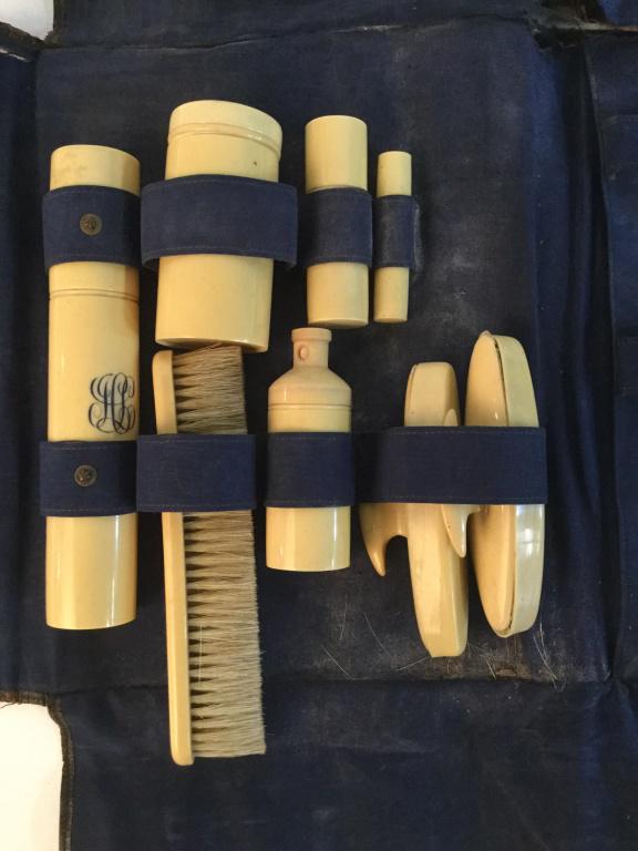 Antique Bakelite Grooming Kit w Travel Case: Antique Bakelite grooming kit with travel case. Leather style carry case with a royal blue fabric lining. The kit includes brushes and several vessels of varying sizes. The largest piece measures 18.4