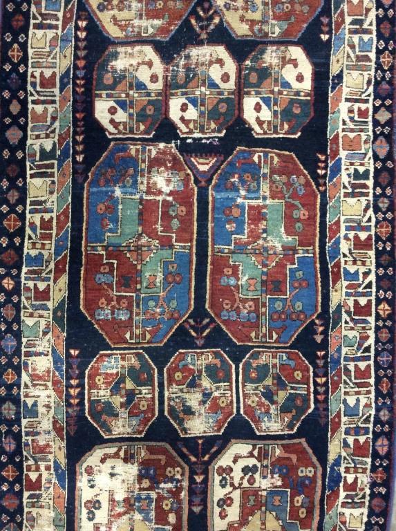 Vintage Handmade Turkish Wool Runner: Rug is vintage Possibly antique. Rug is wool and handmade. Piece has multi toned floral leaf and vine detail with tones of cranberry, green, purple, chocolate, beige, & Slate. Rug measures approx 140 
