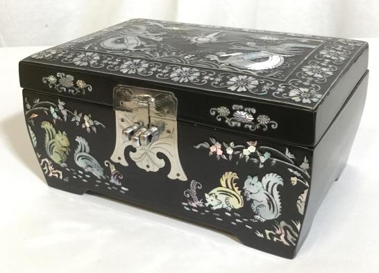 Korean Lacquer Ware Mother Of Pearl Jewelry Box: Korean Lacquer Ware Jewelry Box. The relief detailing is crafted from nacre / mother Of pearl. The detailing depicts a pair of dragons as well as a floral pattern on the lid. On the front, several squ