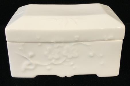 Signed Korean White Porcelain Lidded Box: Signed Korean White Porcelain Lidded Box with cherry blossom and leaf motif, marked on underside under glaze with blue Asian characters, measures approximately 5 inches long x 3 inches wide x 2.75 inc