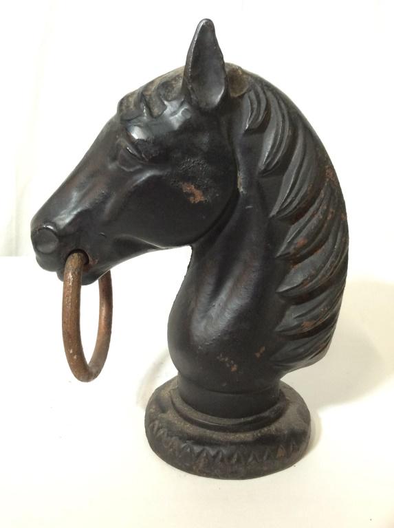 Vintage Cast Iron Horse Head Hitching Post: This piece is a horse head sculpture, cast from iron. The piece is vintage, possibly antique. The horse has a ring in its mouth, the ring appears to be cast from brass. The piece measures approx 9.6 i