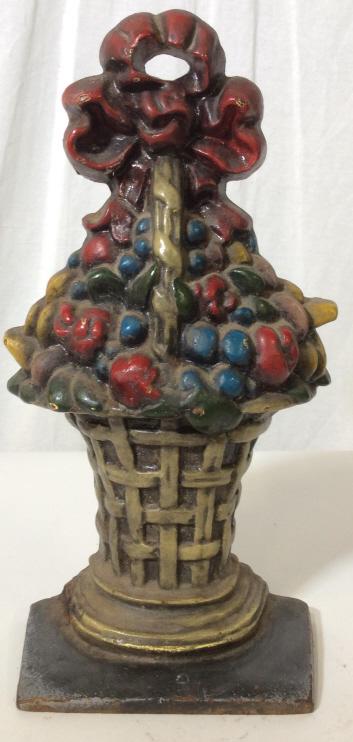 Vintage Cast Iron Floral Basket Doorstop: Vintage Cast Iron Holiday Doorstop, the piece is possibly an antique. The piece is cast to resemble a holiday gift basket filled with fruit / floral bouquet in basket, The piece is hand painted. The p