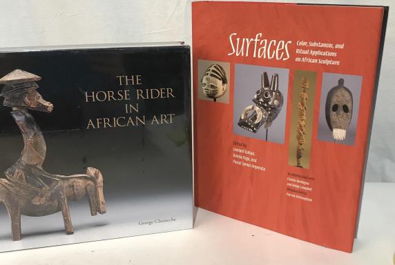 Lot 2 Coffee Table Books On African Art, Signed: ‘The Horse Rider in African Art’ by George Chemeche, in cellophane wrap. 10 3/4 x 9.5 x 1 1/4 in. ‘Surfaces- Color, Substances, And Ritual Applications On African Sculpture ‘ edited by Leonard