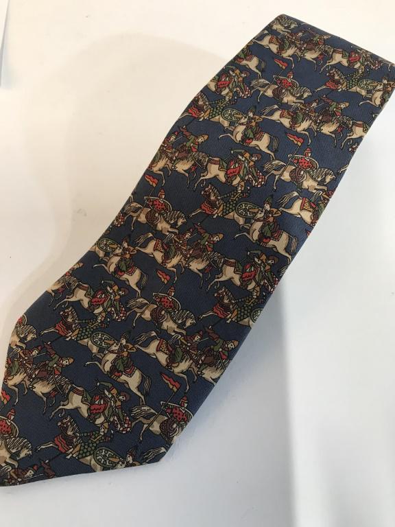 SALVATORE FERRAGAMO Italian Silk Shirt Tie: Exquisite soft and supple 100 % Silk Luxury Designer Tie. Depicts Mongolian Warriors on Horses. Background blue with colors of beige, red & green. Very fine stitching. With Salvatore Ferragamo Label.