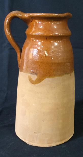 Vintage Earthenware Serving Pitcher: This piece is a vintage earthenware pitcher, clay ceramic pottery, The pitchers Interior is glazed, the top half of the exterior is also glazed. The bottom half of the piece is absent a top coat. The 