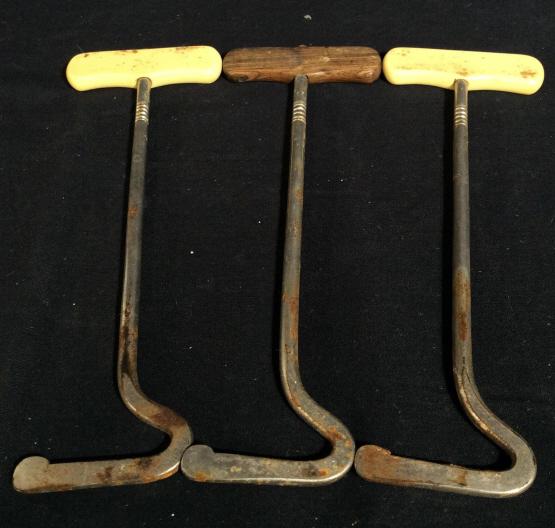 Set 3 Vintage Boot Pulls: This is a set of 3 vintage boot pulls. Two of the three pulls appear to have handles crafted from resin, the third is crafted from wood. The pieces measure approx 8.8 inches H, and 3 inches W. There i