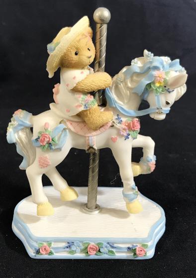 CHERISHED TEDDIES Virginia Carousel Ceramic Figure: The label reads: Cherished Teddies, Virginia. A registration number on the bottom reads 8H2/133. The number on the box and figure reads 506206. The piece has been crafted from ceramic. The piece measu