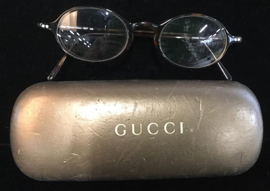 GUCCI Eyeglass Hardcase, C. Klein Glasses, Italy: Lot 2. Hinged Case, Velvet interior with Gucci Logo. No fabric issues int. Ext Case has many nicks in what feels like leather. ‘GUCCI’ in gold written on top. 6 x 2 3/8 x 1 in. Thin frame Calvin K