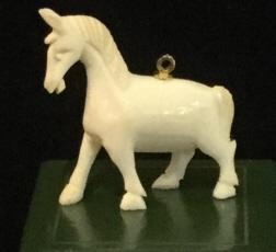 Carved Horse Pendant, jewelry: Pendant of horse, appears to be An Arabian Horse. Possibly resin or composite. Detail of mane, hoof and facial details. 1 1/4 in long by 1 1/4 in tall. Just under 1/5 in wide. Gold toned bail top cent