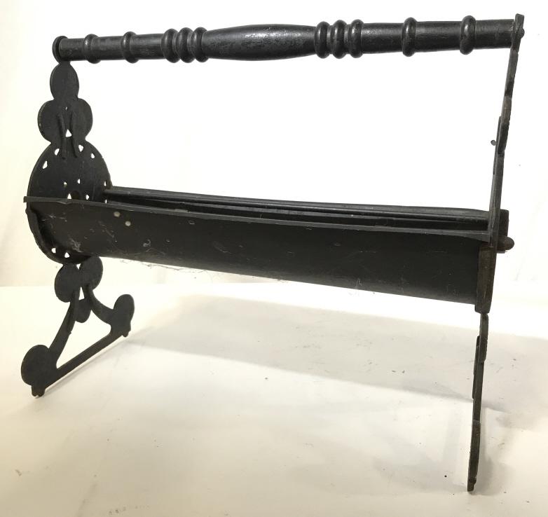 Antique Fireplace Firewood Rack: This is an antique firewood rack. The piece is crafted from iron, wood, and what appears to be tin. The piece measures approx 14.25 inches H, 17 inches W, and 7.5 inches deep. The piece shows signs of