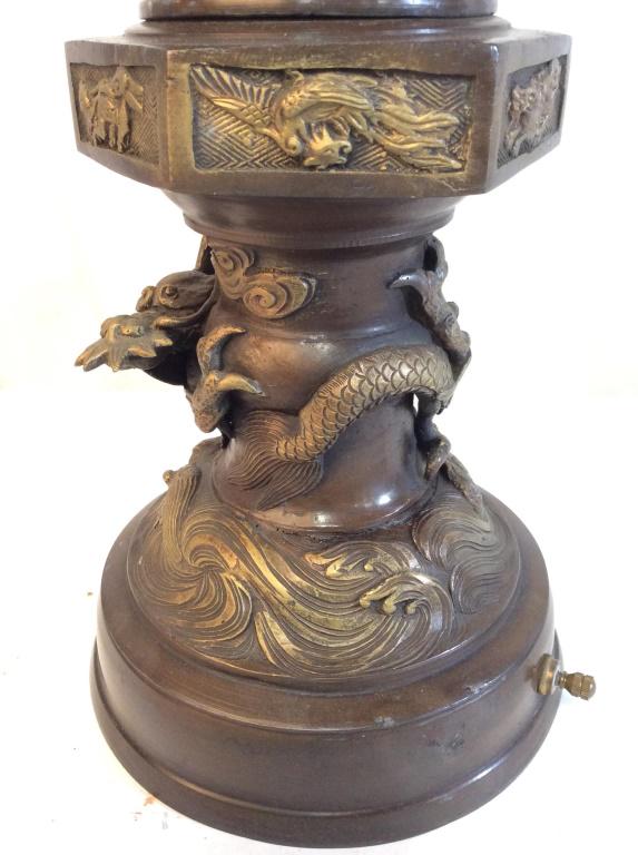 Vintage Chinese Bronze Lamp: Lamp is vintage possibly antique. Piece contains intricate gold toned dragon and fish detail. Piece appears to possibly be bronze. Contains pierced floral detail. Lamp, table lamp, Chinese lamp, bronz