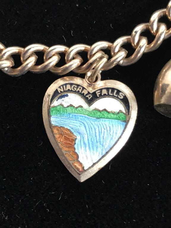 Vintage Charm Bracelet, Jewelry: Gold tone metal, center charm is enameled heart with Niagara Falls in picture & writing. App 6.5 in. Box clasp. Other charms- chair, bottle, wine vessel, bowling pin, more. Vintage Chain Bracelet, Cha