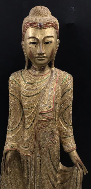 5 ft 7 in Floor Sized Gold Leafed Buddha Statue: 5 Foot 7 Inch Standing Gold Leafed Carved Wooden Buddha Statue with sequined and raised scroll pattern design, statue stands on pedestal base, measures approximately 5 foot 7 inches tall x 22 inches w