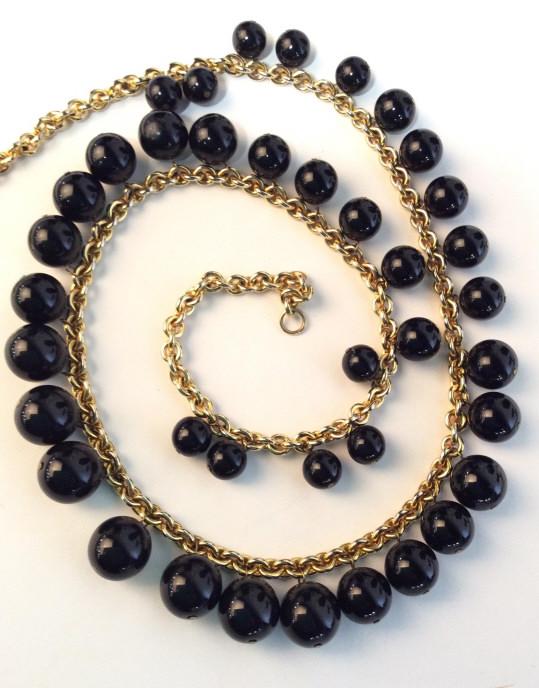 Designer Kenneth Lane Necklace, Signed: gold toned polished metal cable chain w/ graduated (11mm - 15 mm) dangle sphere beads in black. Hook & Loop Clasp, 31 in. Signed Charm that reads ‘Kenneth Lane’. Luxury Jewelry Designer, Kenneth J