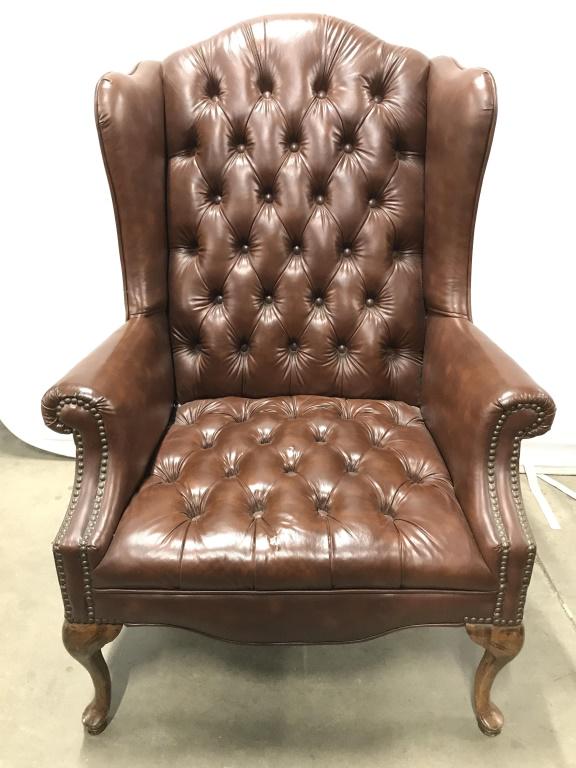 Vintage Wingback Chesterfield Leather Armchair: Armchair is chocolate toned. Chair is Tufted and has winged backrest. Chair appears to Possibly be leather. Chair’s front legs have have cabriole style. Chair has gold toned nailhead detail. Piece m