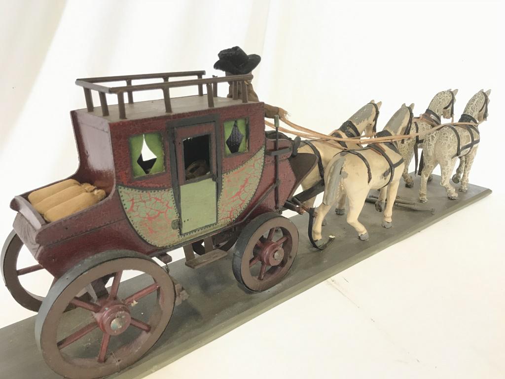 Horse Drawn Coach Carriage Wood Model on Board: Handmade ANTIQUE stagecoach, replica of 19th century transportation, hand painted display model. Fixed to board. Detailed with window drapes, horse reigns, gain sacks, carved wool male Figural with ha