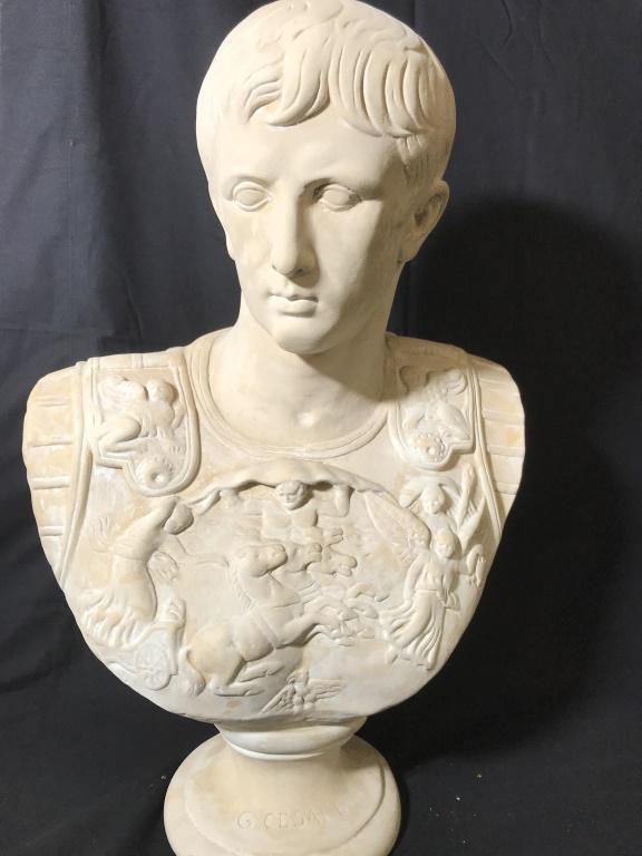 Plaster Roman Bust Of Giulio Cesare: Reproduction of universal art. Sculpture bust of Julius Cesar/ Cesar Augustus in Roman warrior beast plate. Reads on base ‘G CESARE’ 23 in. Ht, 15 1/4 in. wide, app 6 in. wide. Whitewash pottery,