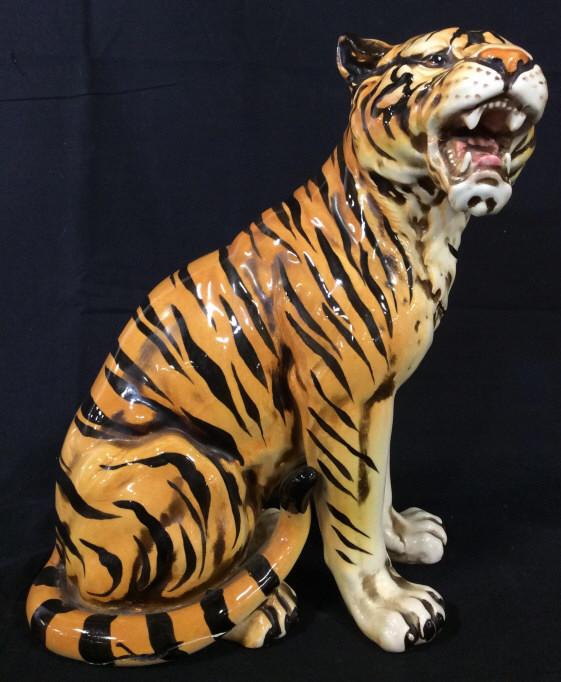 Glazed Ceramic Bengal Tiger Sculpture: This piece is a ceramic sculpture crafted to resemble a bengal tiger roaring in a Seated position. The piece has been hand painted and glazed. There appears to have been repairs made to the piece, on