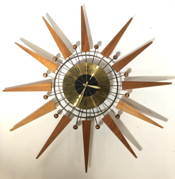 MCM GENERAL TIME CORP Wall Clock: Backside has tag which reads GENERAL TIME CORP. Clockface is Gold Toned & Possibly Brass. Piece has carved wooden geometric structures to create a sun shape. General time clock, general time Corp cloc