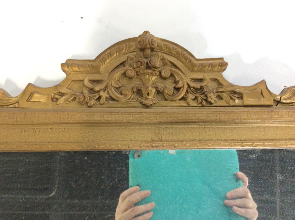 Antique 3 Panel Gilt Wood Victorian Mirror: Intricate carved detail in relief at corners and crown arch. Depicts scrolls with fleur de lis, Greek key pattern border. extra long, 4 ft, 2 in. 21 in tall. Center mirror (25.5 x 13 3/8 in.) flanked 