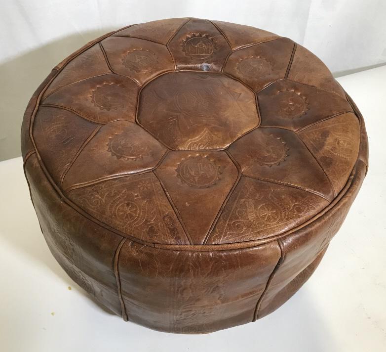 Moroccan Style Brown Leather Pouf: Moroccan Style Brown Leather Pouf With embossed camel and star motif, measures approximately 18 inches in diameter x 9.5 inches tall, some slight wear to leather on edges, some damage to leather on un