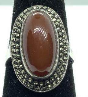 Sterling Silver Ring W Carnelian and Marcasite: Fits size 7/8 approx. sterling silver cocktail ring, marked sterling on interior of band, second hallmark illegible. Dark toned carnelian cabochon framed with two rows of marcasite. Ladies vintage est
