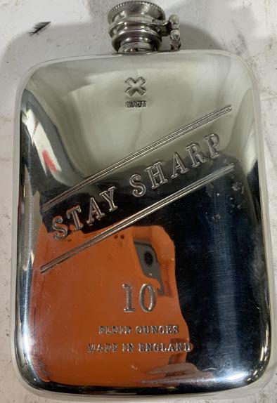 Silver toned drinking flask: Silver toned drinking flask. Front reads x made, stay sharp, 10 fluid ounces, made in England. Measures approx 6 inches tall and 4 inches wide. Screw top. Flask, drinking, drink ware, camp, camping, o