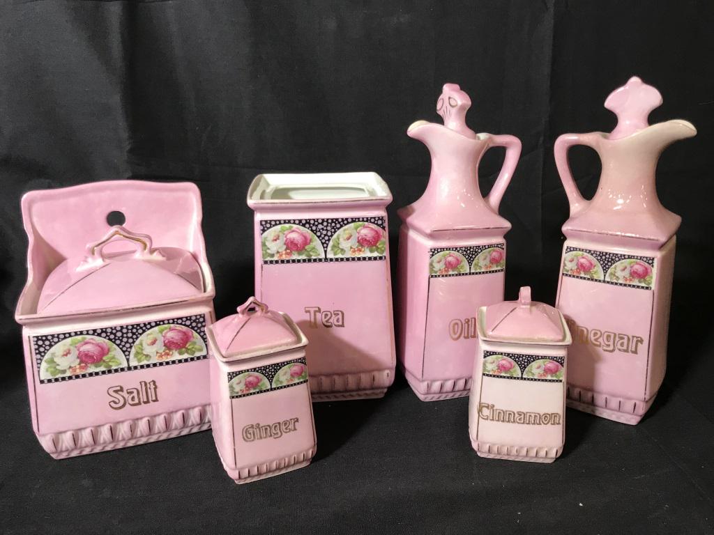 Set 8 German Porcelain Cruets and Canisters: Hand painted pink porcelain kitchen set- salt pot, tea bag canister, oil and vinegar decanters,2 spice jars marked ‘Ginger’ & ‘ Cinnamon’. Flour and rice canisters, no lids, Salt pot, spice ja
