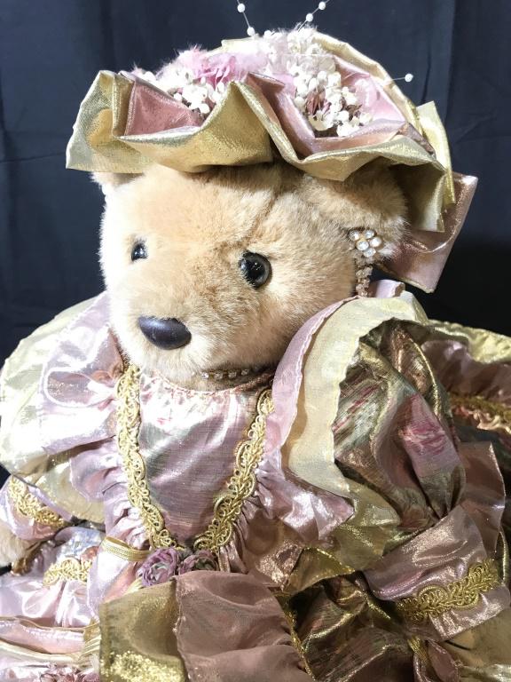 Bearly People Collectible Victorian Stuffed Animal: Elaborate long pink and gold shiny dress with roses on bonnet. She has rhinestone earrings and necklace, carries a hand satchel with tassels in one hand, a heart in the other. Leg s move to sitting po
