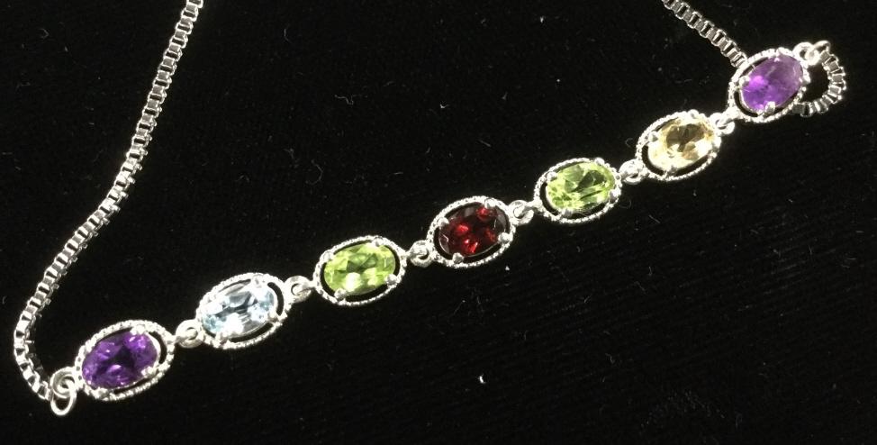 Multi Gem Sterling Silver Bolo Bracelet: 3.25 ctw of gems. African Amethyst, Mozambique Garnet, Brazilian Citrine, Blue Topaz , Periodot. 9 in. Box chain in stainless steel. 925 Sterling for Gem setting. Bolo bracelet fits any size. New. Nev