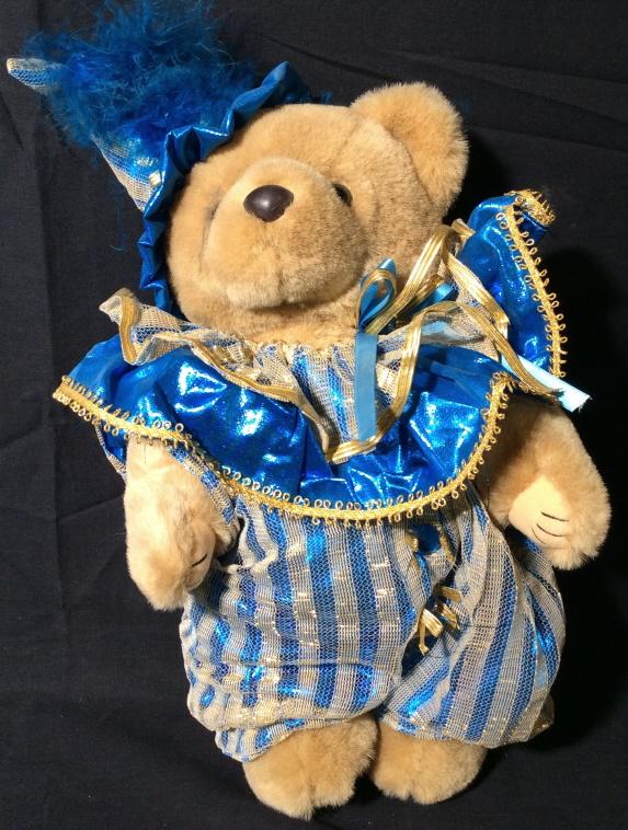 BEARLY PEOPLE Collectible Jester Bear: This is a vintage stuffed bear by BEARLY PEOPLE. The piece depicts a bear in a jester-like outfit, the outfit is colored a metallic blue and is overlaid by gold mesh. The piece measures approx 14 inch