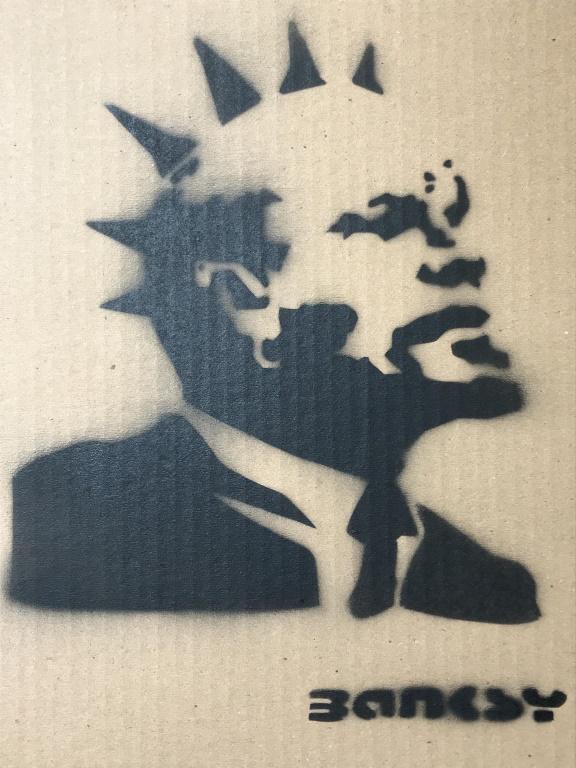 Signed Paint on Cardboard, Punk Lenin after BANKSY: The piece is spray paint on cardboard, after BANKSY (English, active 1990’s-Present) The piece is BANKSY’s PUNK LENIN piece, this depicts Vladimir Lenin with a mohawk and earrings. The piece is si