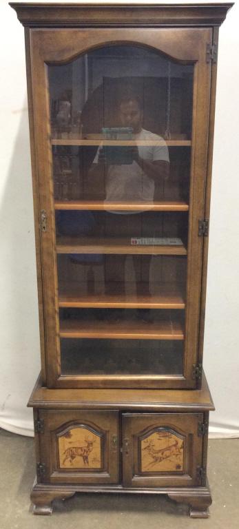 Carved Wooden Display Shelf: Piece contains 5 shelves. Appears to have wooden pieces to have piece double as rifle rack. Lower area of piece has Cabinet doors with depiction of deer. Piece has carved wooden feet. Measures approx 