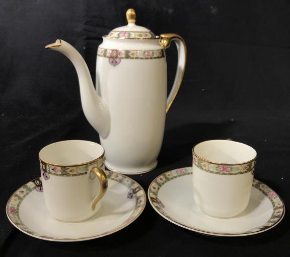 Noritake Nippn Dematasse Tea Set for 2, Japan: 5 pc set tea/coffee set with 2demitasse cups, 2 saucers, 1 tall teapot with lid. 7 x 7 in. White porcelain, decorative rim border, gilt rim and handles. Underside Noritake hallmark with Japanese chara