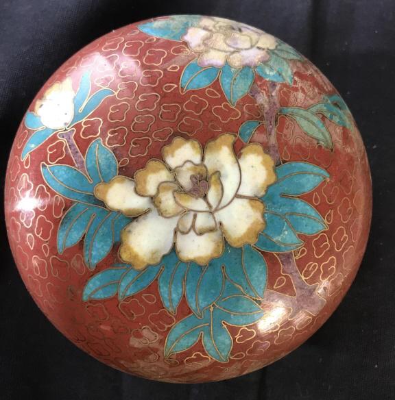 Lot 2 Lidded Trinket Boxes, Cloisonné and Shell: Vintage orange cloisonné round box, painted blue enamel interior, lid with center flower, 4 in. wide. Light discoloration. Vintage Brown flat shell box with brass handle, base and interior. Marked 25
