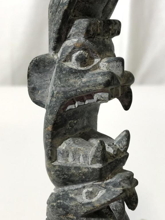 Carved Stone Tiki Totem Pole Figure: Tiki is carved stone. Piece has multiple carved stone animals. Piece measures approx 7.5 inhces tall 1.5 inches wide. Tiki, totem pole figure, stone tiki. Piece has some chips. tableware, tabletop dec