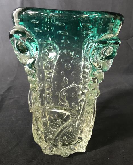 Decorative Art Glass Vessel: This is a decorative art glass vessel, the piece is colored in teal tones. The piece also features a bullicante-style pattern throughout, as well as raised detailing. The piece measures approx 9.4 inc