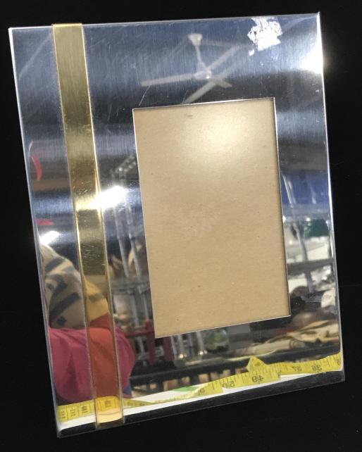 Silver toned and Gold tone Picture Frame: Brushed silver tone metal frame, possibly silver plate, with accent gold tone stripe, also brushed metal. Frame size is 7.25 x 5 5/8 in. Horizontal or vertical positioning. Back slides out. Picture fr