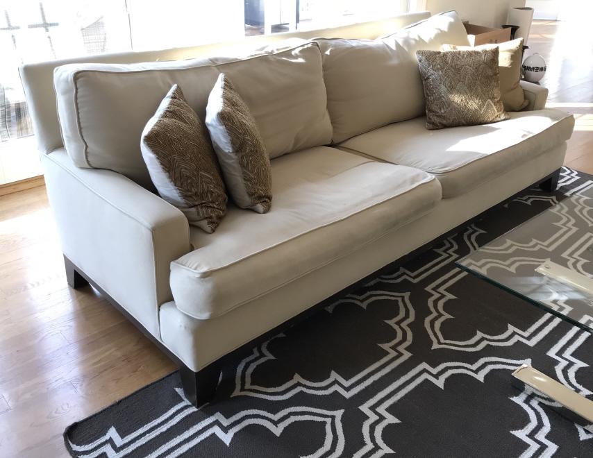 Pottery Barn Cream Toned Sofa: Pottery Barn Cream Toned Sofa With dark wooden base/legs, two large seat cushions and two large back cushions, measures approximately 92 inches long x 33 inches tall at back x 41 inches deep, marks to