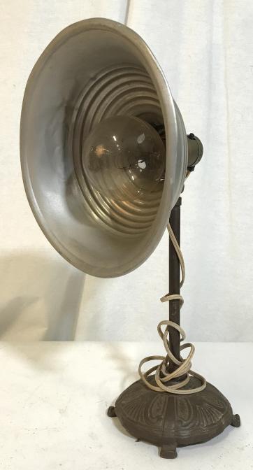 Vintage Metal Assemblage Table Lamp: Vintage, possibly antique, desktop lamp. Base appears to be cast from iron. Piece measures approx 13 inches H, the base has a diameter of approx 5.25 inches, the shade has a diameter of approx 8.75 in