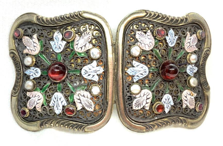 Enamel and Semi Precious Stones Belt Buckle: Nickel metal, reticulated swirl and filigree design, red tone semi precious stones, pearlescent shell details, enamel floral design, together measures approx 4 in by 2 1/2 in. Discoloration to metal, 