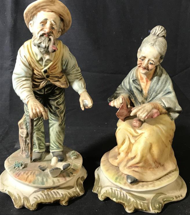 Lot 2 Vintage Porcelain CAPODIMONTE Figures: Undersides of each are marked CAPODIMONTE MADE IN ITALY. Lot includes 1 elderly male & 1 elderly female figure. Each appear to be porcelain. Pieces are possibly hand painted. Tallest piece in lot meas