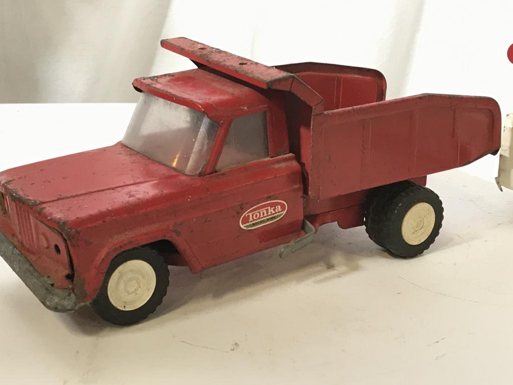 Vintage Collectible TONKA Trucks, Set 2 Toys: Red, pressed Steel TONKA dump truck. Lift lever and back ‘dumps’. Vintage surface discoloration. Wheels move very well. Tonka sticker on sides of doors. Possibly c. late 1960s, early 1970s. White,