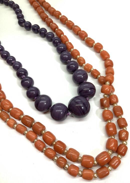 Lot 2 Beaded Necklaces: One with orange beads with costume pearl spacer beads, orange beads possibly coral, possibly natural stone. 12k gold filled clasp, marked 1/20 12 k 1 GF.Hangs approx 22 in long. Purple glass beaded ne