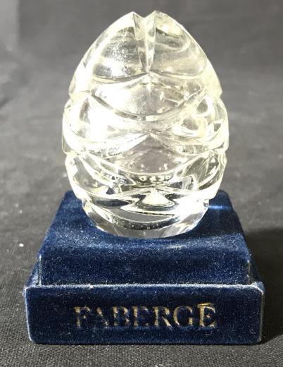 FABERGE Cut-glass Decorative Egg: This is a decorative egg from FABERGE. The piece measures approx 2.5 inches H and 1 inch W. The piece includes a stand. The egg is engraved on the bottom with the year of production, the company name,
