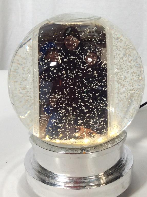 Electronic Snow Globe & Picture Frame: This piece is an electric snow globe. The piece contains a motor to move snow around the globe, and lights to illuminate it. A removable insert allows for the addition and removal of photos. The piece