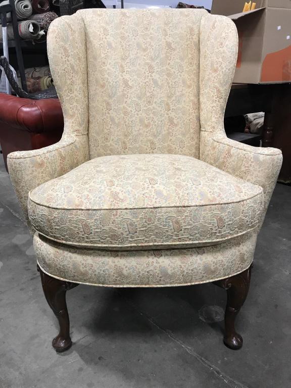 Vintage Wingback Chair W Carved Wooden Feet: Chair has winged backrest. Piece has intricately carved wooden feet with c curved detail. Piece has intricate multi toned detailed upholstery. Piece measures approx 43 inches tall 33 inches wide and d