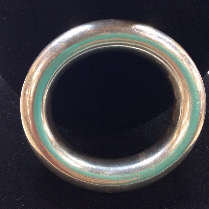 Signed TIFFANY ‘Elsa Peretti’ SS Bangle, Italy: Dwt 52.2. Vintage Tiffany & Company Sterling Silver Rounded bangle, just under an in. wide, flanks measure.5 in deep. Labeled 925 and Italy. Signed and copyrighted by Elsa PERETTI. Slight oval shape, 