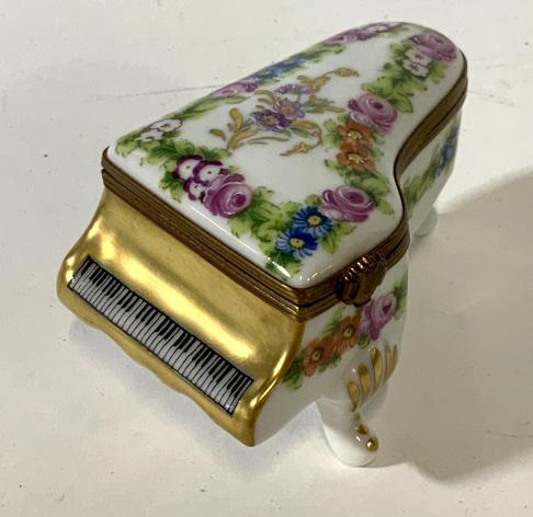 Lot 2 vintage Limoges Pill Boxes: Lot includes 2 trinket boxes marked Limoges France on bottom. One box is a piano with floral patterned painting. Measures approx 4 inches long and 2.5 inches tall. Clasp closure, bottom reads Limoges 